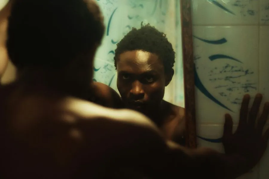 man looking at face in the mirror